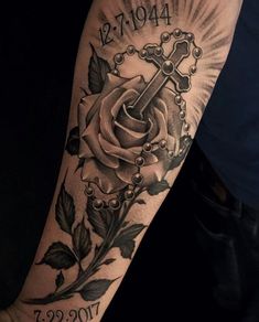 a man with a cross and rose tattoo on his arm