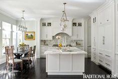 a large kitchen with white cabinets and an island