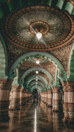 the inside of an ornate building with columns and arches on either side of the walkway