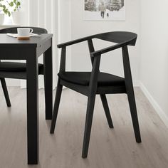 two black chairs sitting next to each other on top of a wooden floor