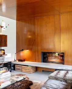 a living room filled with furniture and a fire place in the middle of it's wall