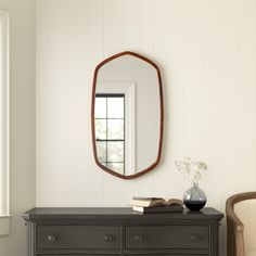 a room with a dresser, mirror and chair