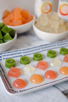 there are many different types of candy on the plate and in bowls next to each other