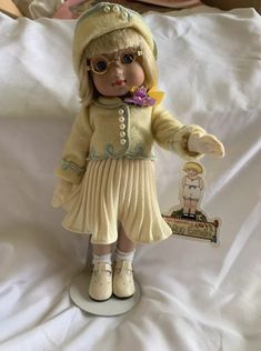 a doll with glasses and a hat on top of a bed