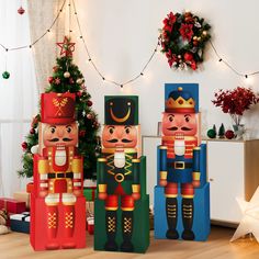 three wooden nutcrackers standing next to each other in front of a christmas tree