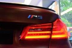 the back end of a bmw car with its lights on