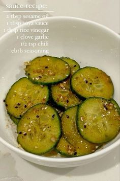 a white bowl filled with sliced cucumbers on top of a table