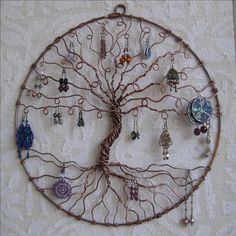 a metal tree with many different colored beads hanging from it's branches on a white wall