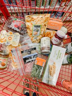 a shopping cart filled with lots of food and condiments on top of it