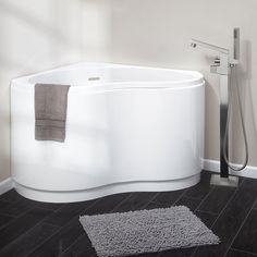 a white bath tub sitting on top of a wooden floor