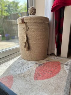 a large basket sitting on top of a rug next to a window