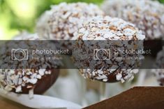 chocolate covered candies with coconut flakes on top in a cardboard box, ready to be eaten