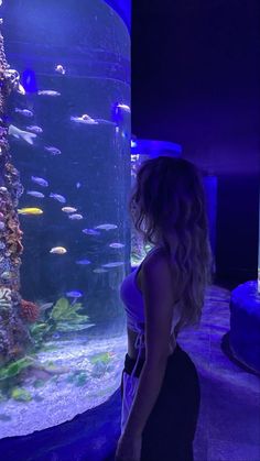 a woman standing in front of an aquarium