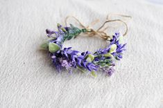 a wreath made out of purple flowers on top of a white cloth