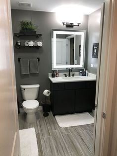 a bathroom with a toilet, sink and mirror in the middle of it's room