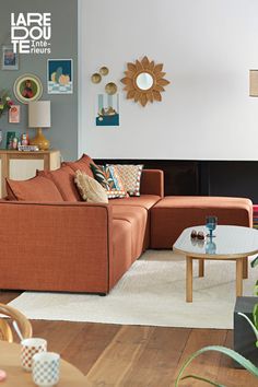 a living room filled with lots of furniture next to a wall covered in pictures and plants