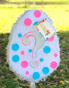 a paper mache with a question mark on it sitting in the middle of grass