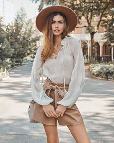 Relaxed Fit 100% Polyester Hand Wash Cold. Dry Flat Split Neckline with Neck Tie Long Sleeves with Elastic Cuffs Textured Fabrication No Closures Not Lined¨CSheer Our Sheer Bliss Peasant Blouse is so transitional! This cream split neck peasant blouse is crafted with long billowy sleeves. Pair this sheer top with faux leather shorts and booties! Styled with the El Dorado Hat. Perfect Hoop Earrings. Gigi Double Coin Necklace. On The Fly Crossbody Bag. Streetside Pocketed Faux Fur Jacket. Roxbury P Off Shoulder Evening Gown, Faux Leather Shorts, Blouse Sale, Blouse Price, Mini Skater Dress, Distressed Denim Jacket, Cropped Denim Jacket, Peasant Blouse, Leather Shorts