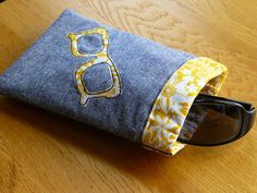 a pair of sunglasses sitting on top of a denim case