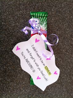 a candy bar wrapped in pink and green paper with a ribbon tied around the top