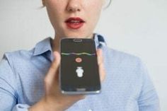 a woman holding up a cell phone with an apple logo on the front and side