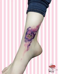 a woman's foot with a purple flower tattoo on her left side calfocks