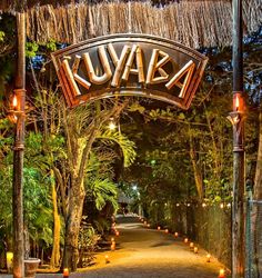 the entrance to kuvaka is lit up at night with candles on either side