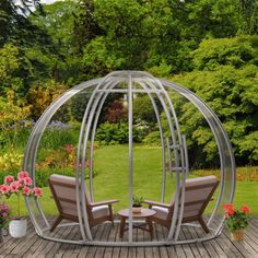 two chairs are sitting in the middle of a wooden decked area with a glass dome