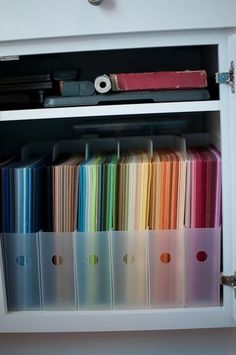 an open cabinet filled with lots of different colored papers