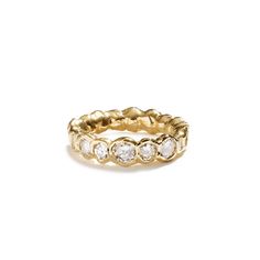 a gold ring with five round diamonds on the inside and outside, set against a white background