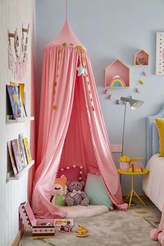 a child's bedroom with pink canopy bed and toys on the floor in front of it