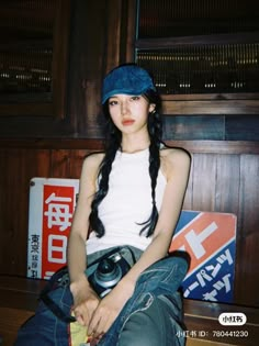 a young woman sitting on top of a wooden bench with a camera in her hand