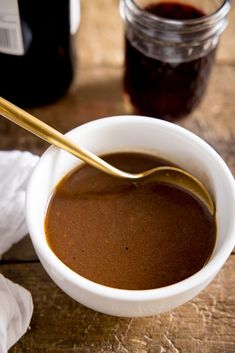 a spoon in a bowl filled with brown liquid