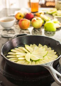 apples are being cooked in a skillet on the stove with other ingredients around them