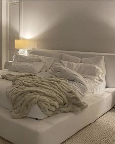 a bed with white sheets and blankets on it