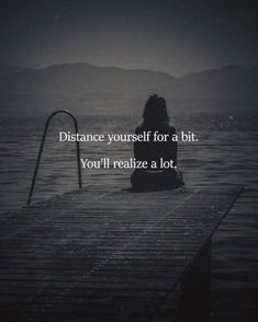 a woman sitting on top of a dock next to the ocean with a quote about distance