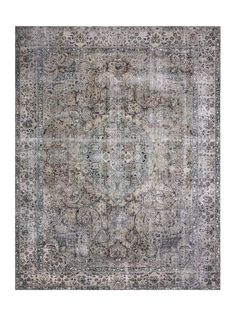 an antique style rug in grey and blue tones with a medallion design on the center