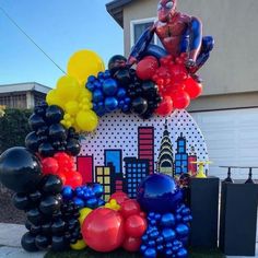 an inflatable balloon arch with spiderman on top and balloons all around it