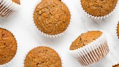 several muffins are lined up on a white surface