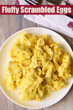 scrambled eggs on a white plate with fork and knife in the background text reads fluffy scrambled eggs