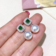 Highline: Classic Earrings Style Product Information Origin Japan MaterialAkoya Pearl, 18k White Gold, Natural Diamond, and Emerald DimensionsEarrings Length 2.2 cm  Pearl Shaped: Round Size: 9.5-10 mm Quality: AAA Nacre: Very Thick Color: White Luster: Aurora  Accessories Metal: 18k White Gold Other: 0.41 ct of SI Quality Natural Diamonds, and 0.65ct of Natural Emerald Including With Your Purchase: 30-Day Money-Back Guarantee Company Certificate Exquisite Gift Box Pearl Earrings Designs, Pebble Jewelry, Pearl Jewelry Design, Saltwater Pearls, Solitaire Earrings, Diamond Jewelry Necklace, Pearl And Diamond Earrings