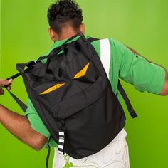 a man with a backpack on his back is looking down at something in his hand