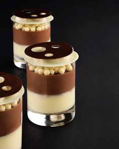 three desserts in small glass containers with chocolate and white toppings on the top