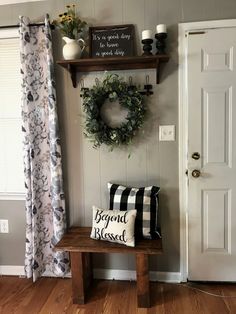 a wooden bench sitting in front of a door with a wreath on top of it