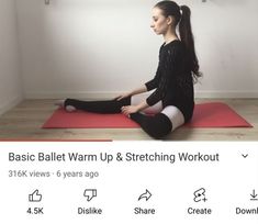 a woman sitting on top of a red yoga mat in front of a white wall