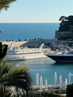 a cruise ship is docked in the water next to other boats and yachts at a dock