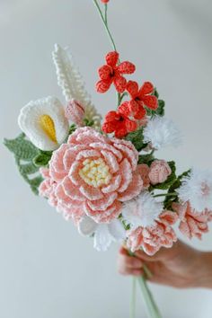 crocheted flowers are being held by someone's hand