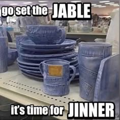 a pile of blue jeans sitting on top of a shelf next to other denim items