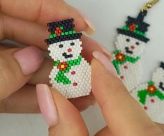 someone is holding some beaded snowmen in their hands