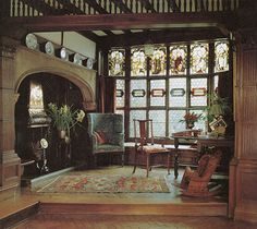 an ornate living room with wood paneling and stained glass windows